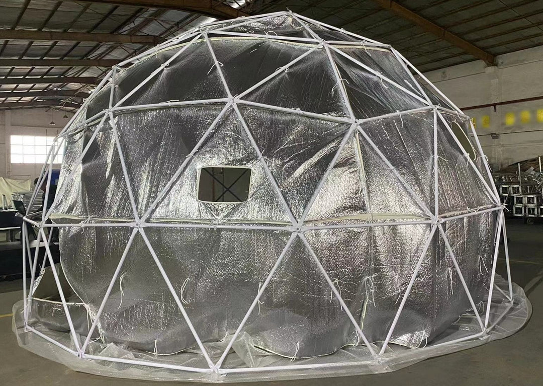 Geodesic dome tent by Glamping Dome Store in Calgary, Alberta, Canada, featuring a sturdy white powder-coated frame and reflective bubble foil insulation hanging inside the dome structure. The insulation includes a standard-size mesh-screen vent opening for improved air circulation and interior comfort.