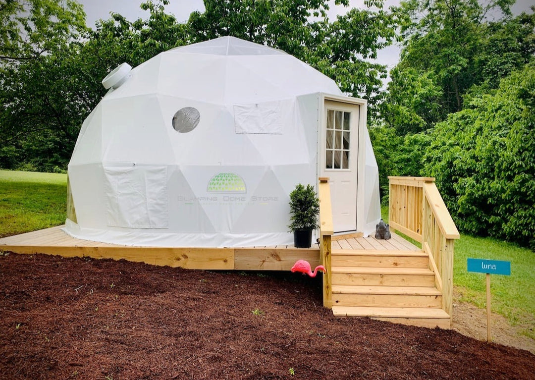 Geodesic dome tent sold by Glamping Dome Store, 19.7 feet (6 meters) in diameter, installed at Tiny Haven Living near Harpers Ferry, West Virginia, USA. The dome features a weather-resistant white PVC cover, set on a wooden deck with stairs, surrounded by lush greenery, perfect for eco-friendly retreats and glamping accommodations.